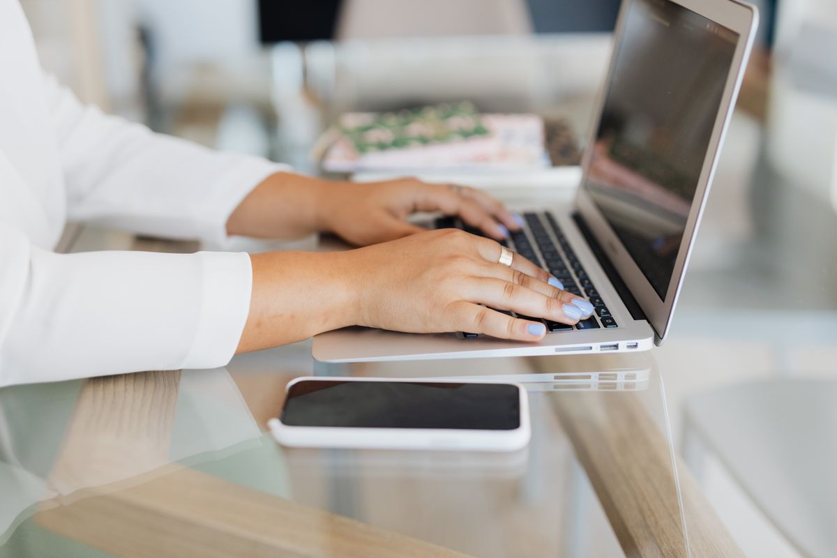 Persona escribiendo en un portátil mientras cambia la dirección de su cuenta de Gmail